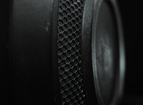 Detailed macro shot of a speaker with a hexagonal textured pattern and a dark tone.