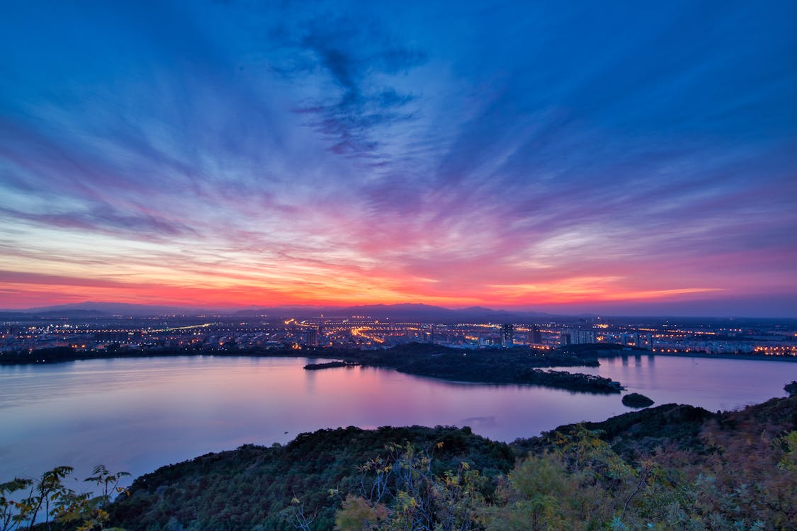 Body of Water Under Blue and White Sky at Golden Hour