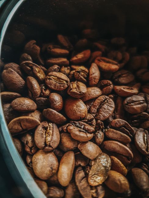 Detailed view of roasted coffee beans in a container in São Paulo, capturing rich textures and earthy tones.