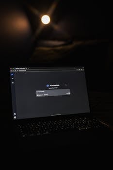 Dimly lit room featuring a laptop with an AI chat application screen visible, creating a tech-focused ambiance.