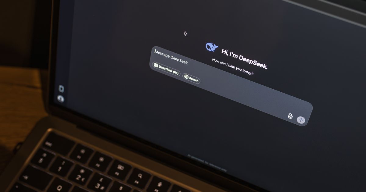 A laptop on a wooden table showing an AI chat interface on its screen