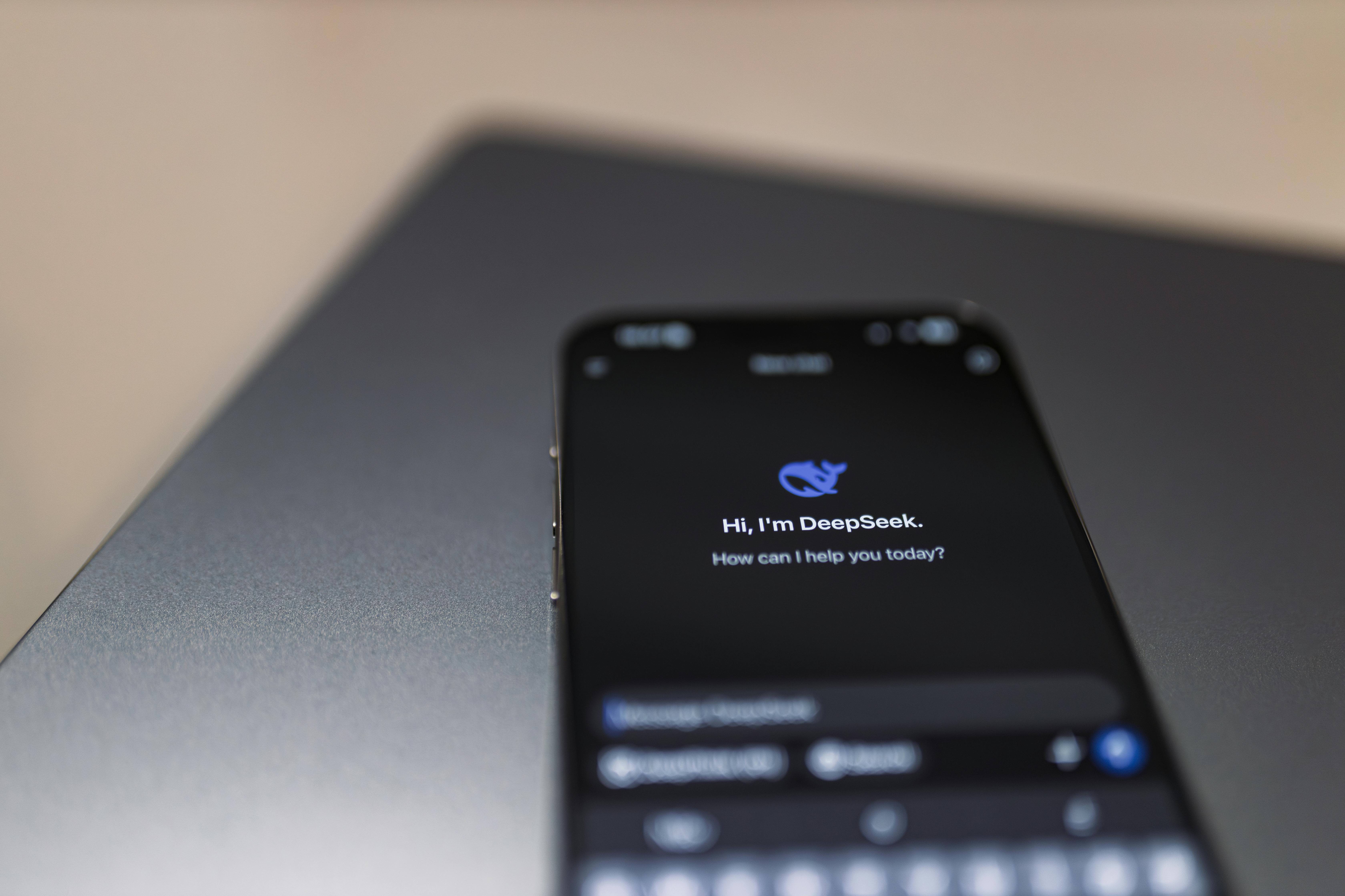 Kostenlos Nahaufnahme eines Smartphones mit KI-Assistentenschnittstelle auf dem Bildschirm über einem Laptop. Stock-Foto