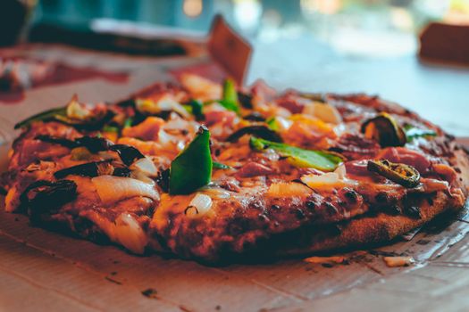 Close-up photo of a freshly baked pepperoni pizza topped with vegetables.
