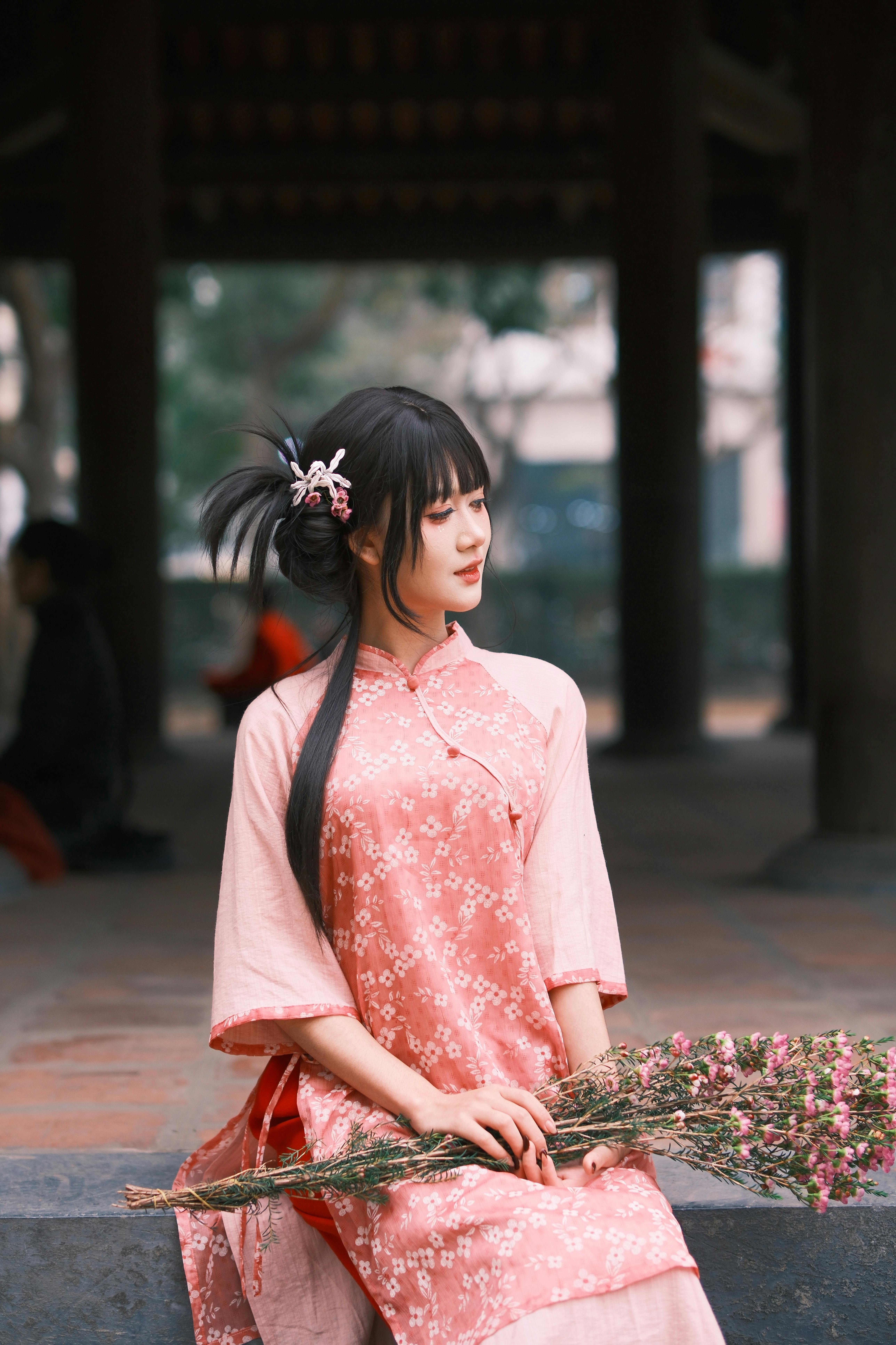 elegant woman in traditional pink dress holding flowers