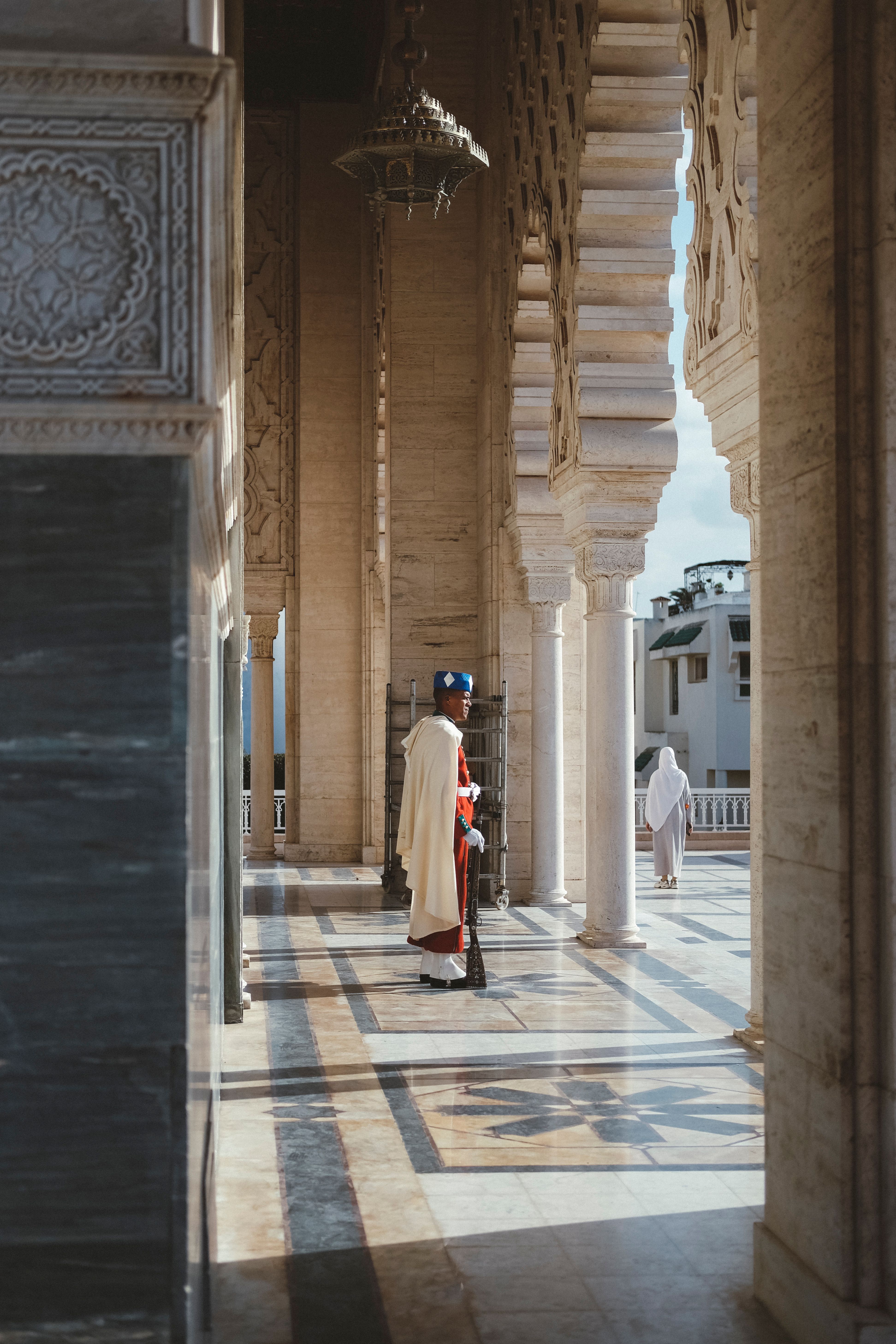 A serene scene at Hassan Tower featuring a royal guard under intricately designed arches.