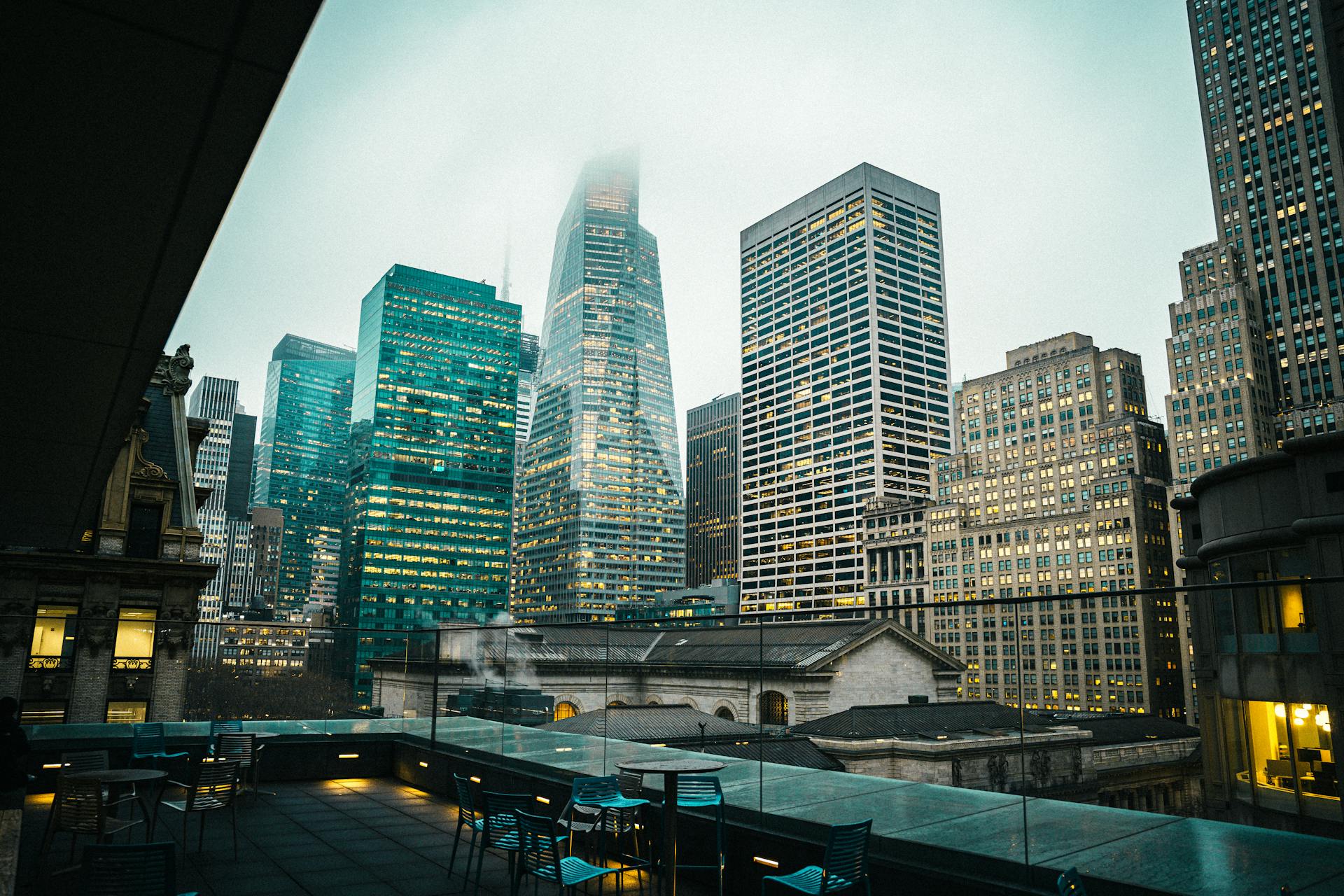 Misty New York City skyline showcasing iconic skyscrapers from a rooftop perspective.