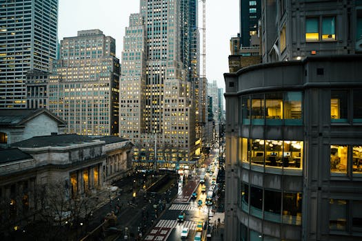 A bustling street scene in New York City with iconic skyscrapers and evening lights.