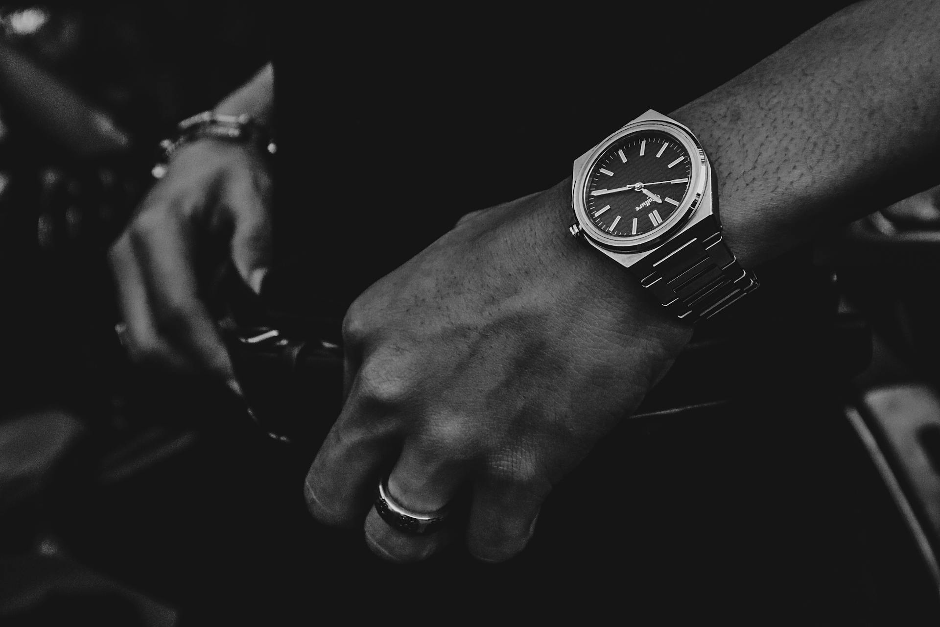 Stylish wristwatch on a man's hand, emphasizing elegance and time management in monochrome.