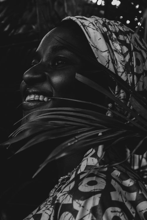 Free Artistic black and white portrait of a smiling woman among leaves. Stock Photo