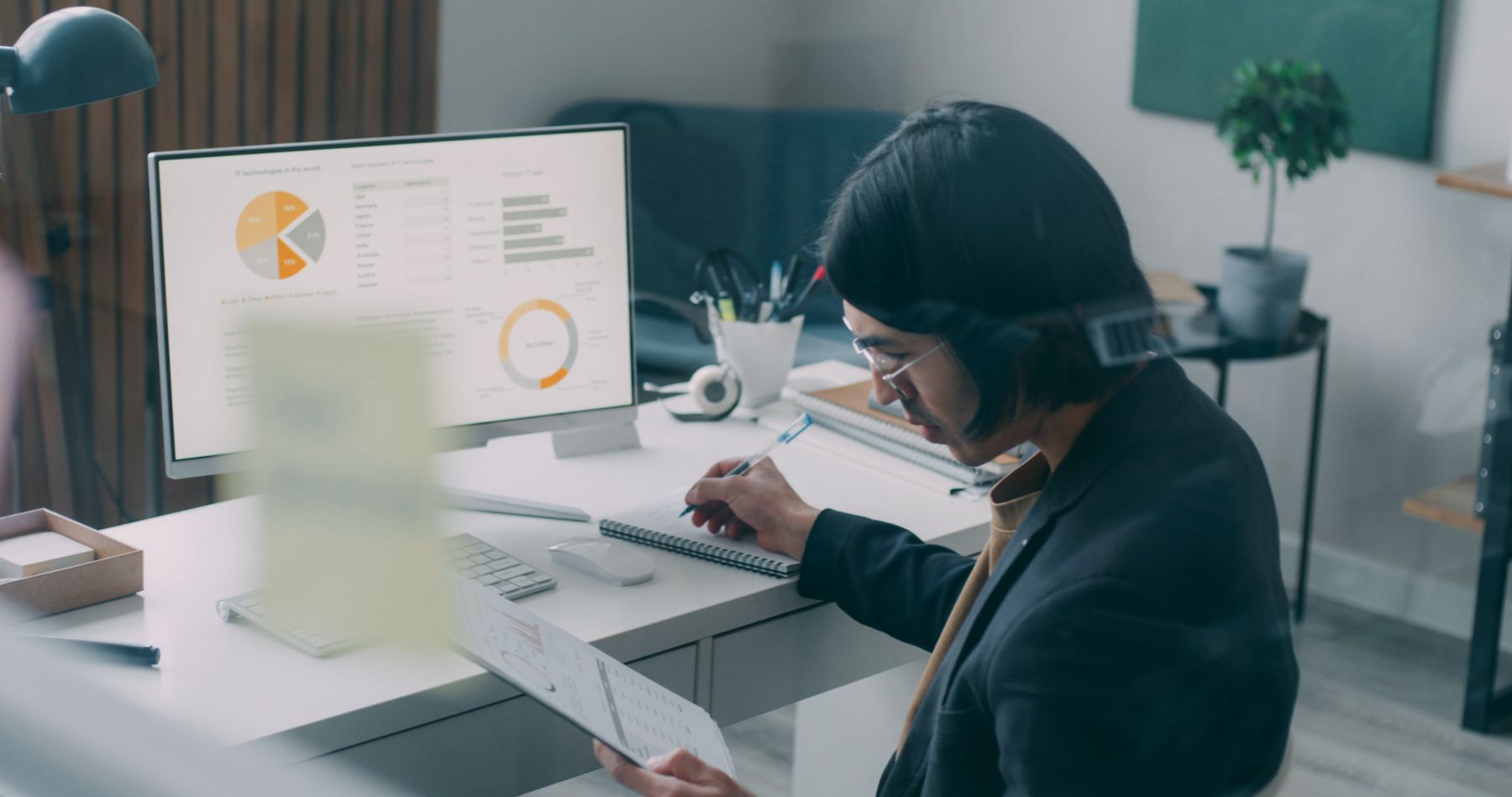 A business professional analyzing charts and records at a desk
