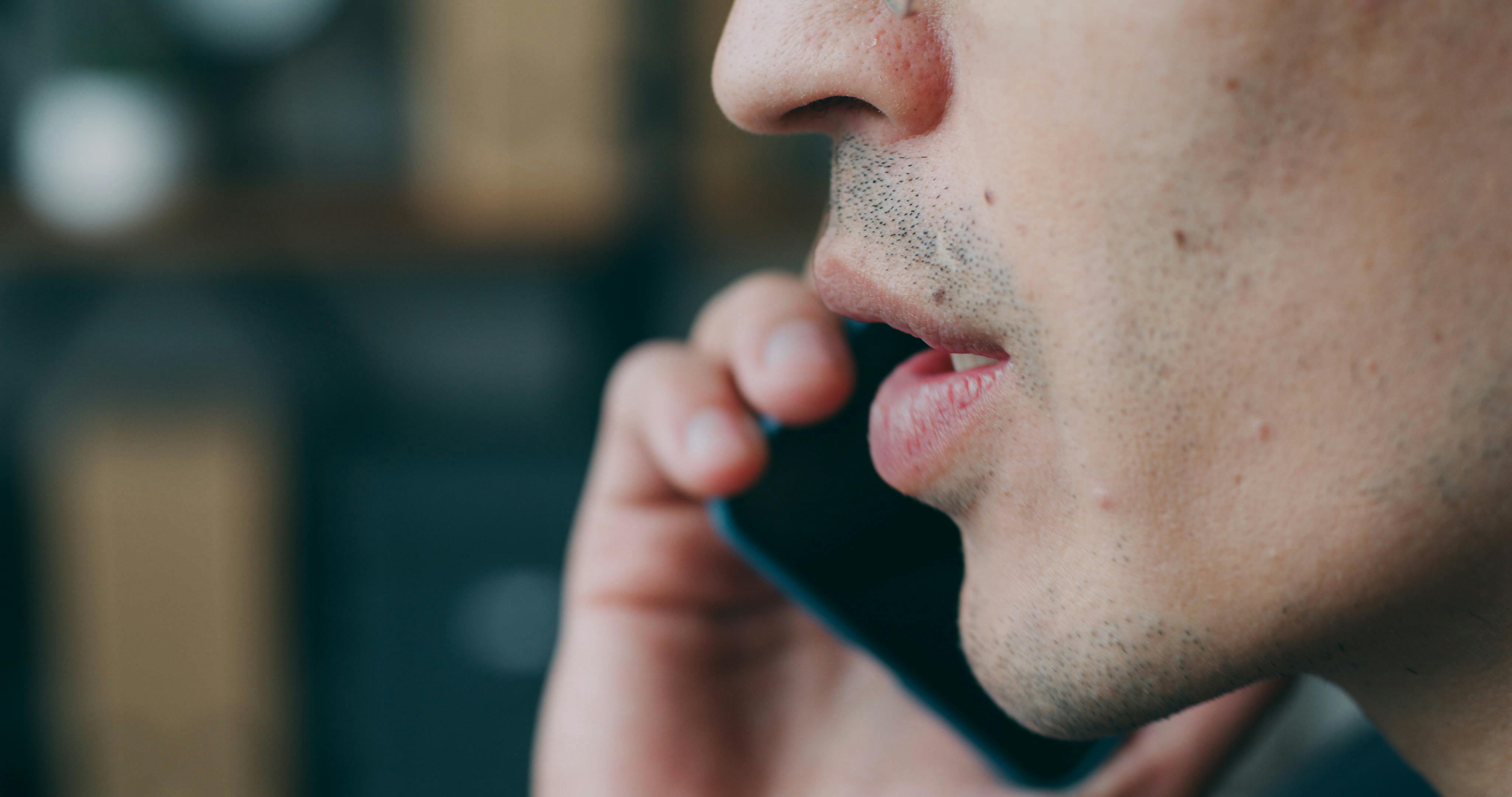 grátis Close Up De Boca Masculina Falando Ao Celular Contra Fundo Desfocado De Escritório. Comunicação Profissional E Conceito De Tecnologia Moderna. Foto profissional