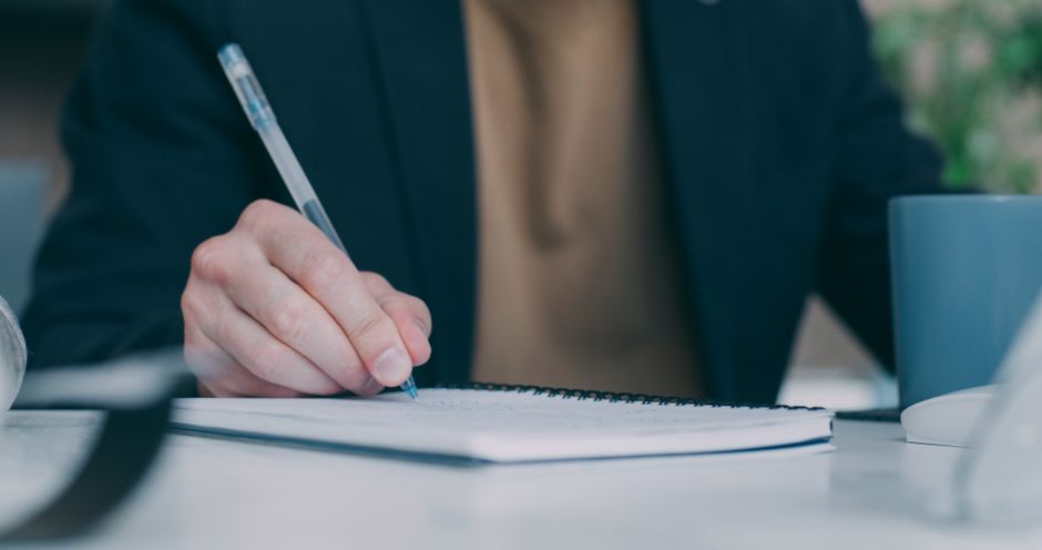 Fondateur qui note son plan marketing dans un carnet au bureau
