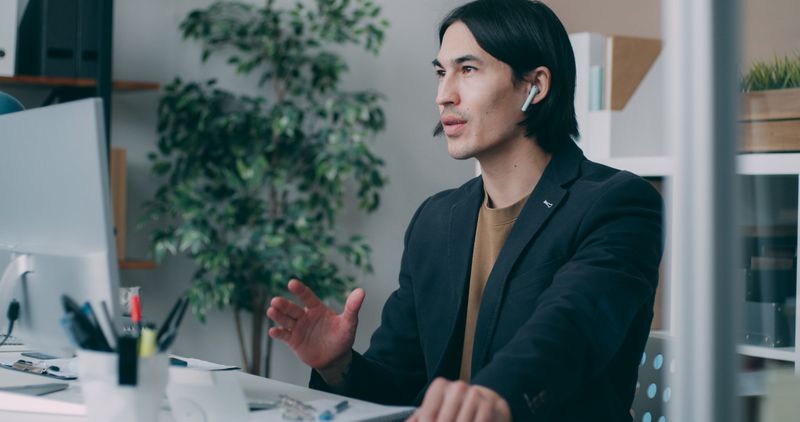 A person in headphones working at a desk — Vitaly Gariev on Pexels
