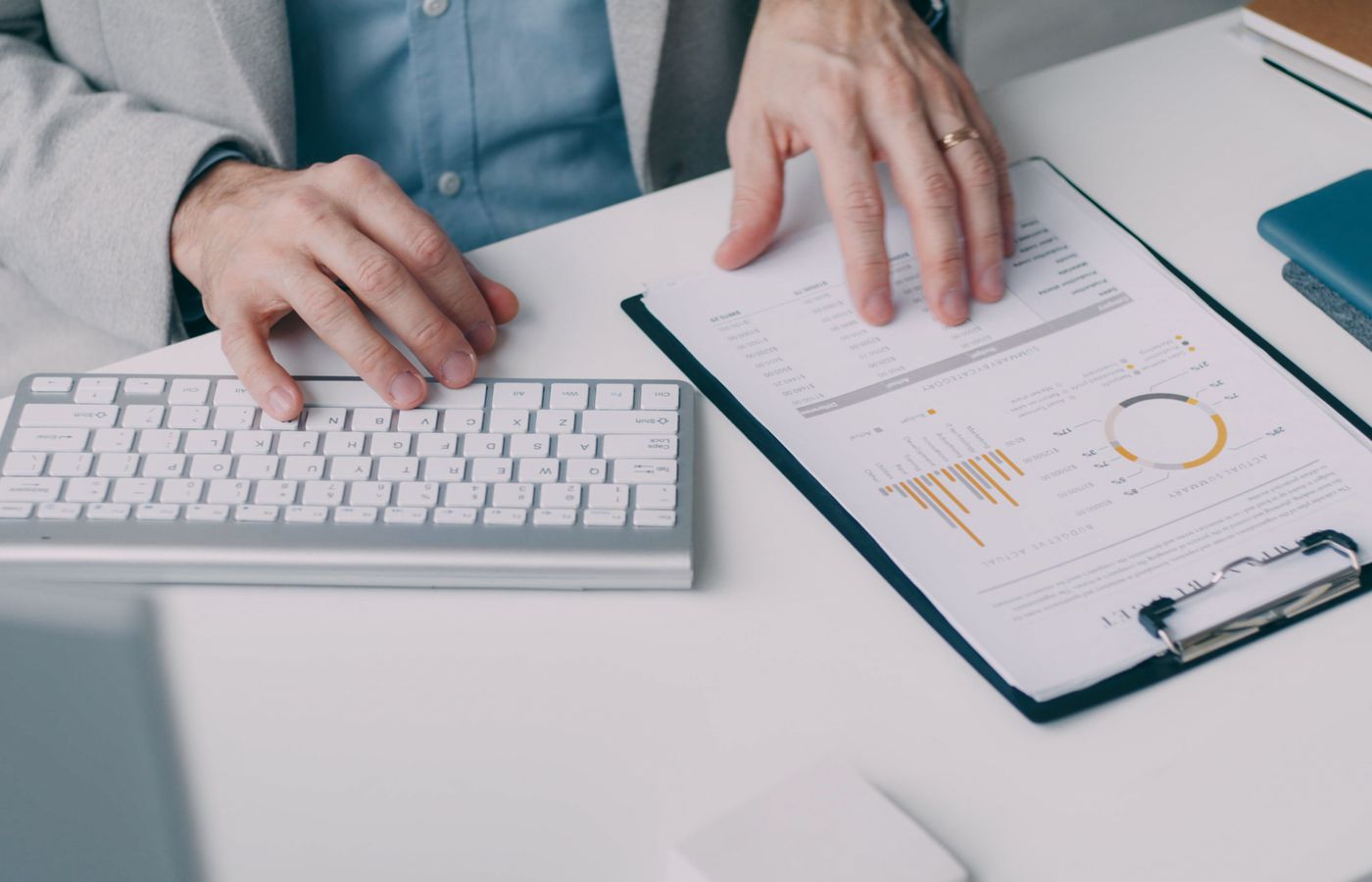 A man working with a financial report and keyboard in an office setting.