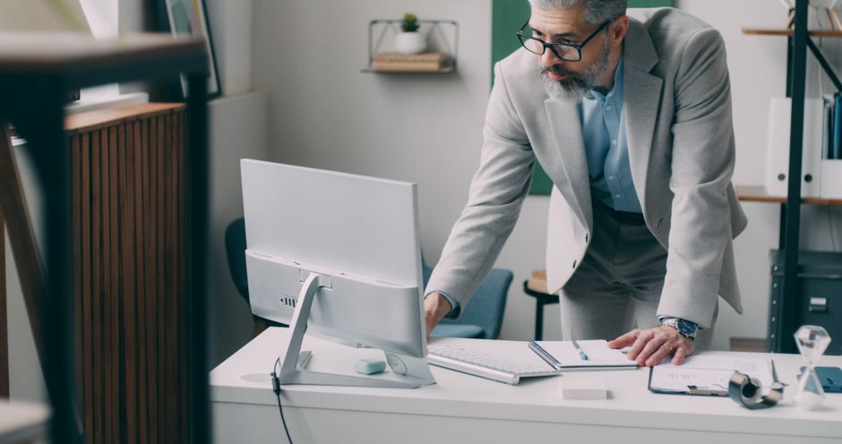 Why Browser-Saved Passwords Fail — What Experts Recommend A mature businessman in a suit focusing on work at his computer in a modern office.