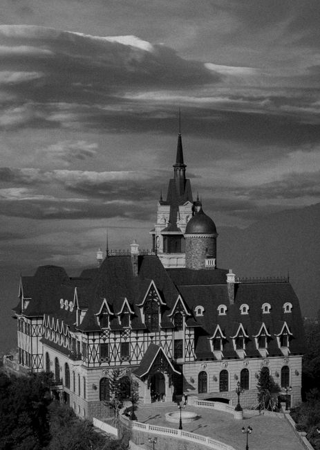 A stunning Gothic Revival castle with intricate roof design under a dramatic sky.