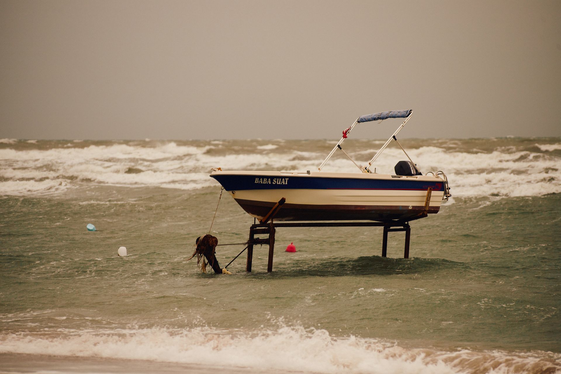 A lone boat named Baba Suat stranded on a rough sea with winter waves crashing.