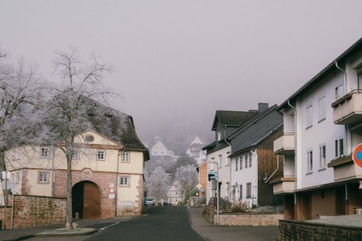 Frosty streets with medieval architecture showcasing European heritage in winter fog.