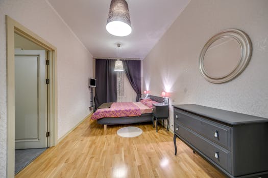 Stylish modern bedroom with wooden flooring and elegant furnishings.