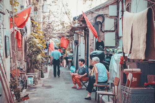 Two Women Sitting on Alley