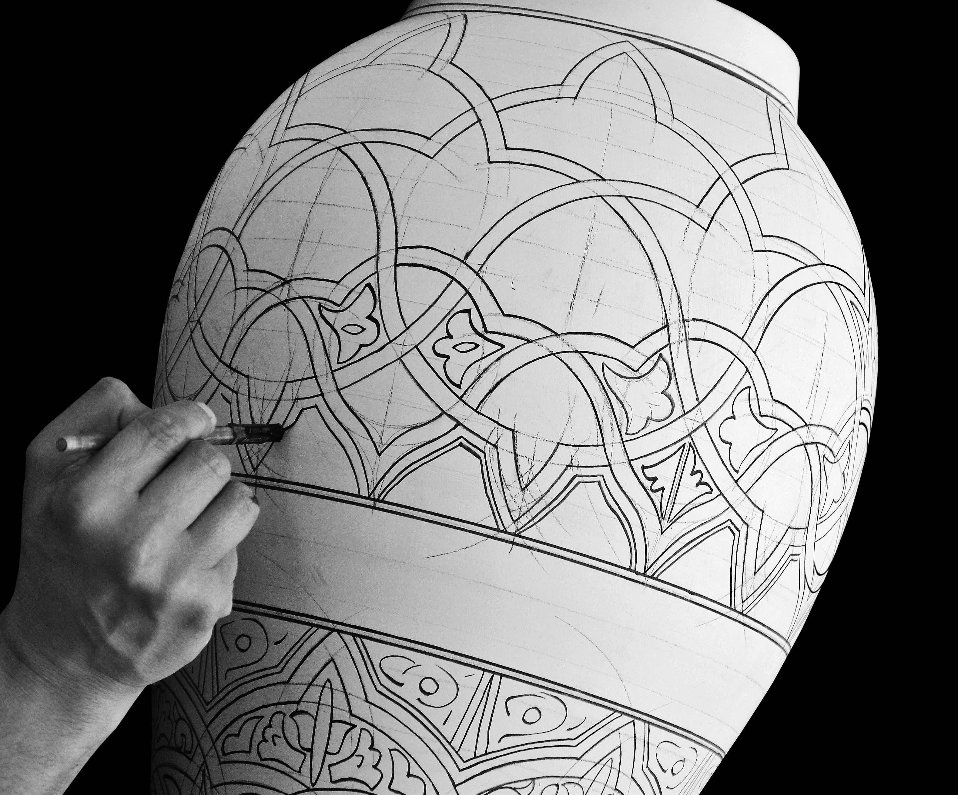 A skilled artisan hand-painting intricate patterns on Moroccan pottery, highlighting traditional craftsmanship.
