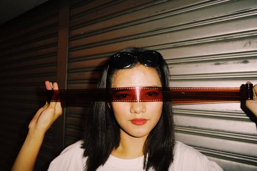 一位女性在城市环境中用胶片当作太阳镜的创意肖像