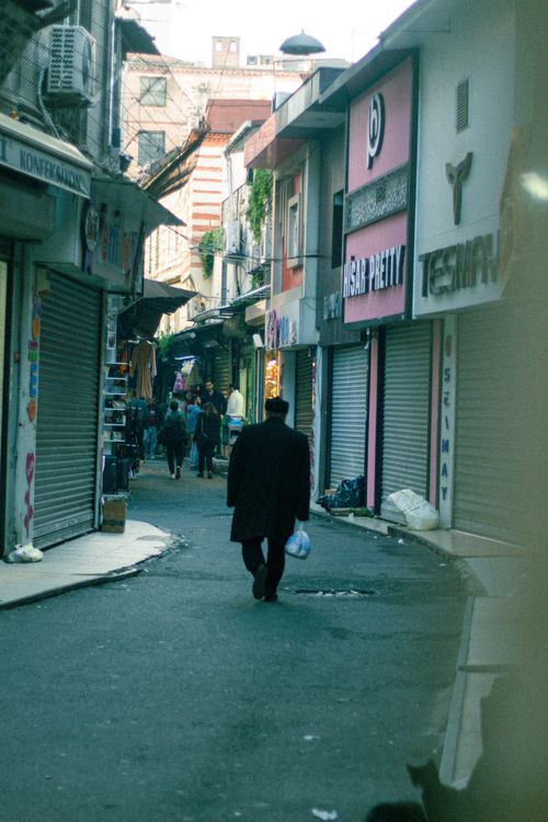Free A bustling backstreet in Istanbul lined with shops and a man walking down the narrow alley. Stock Photo
