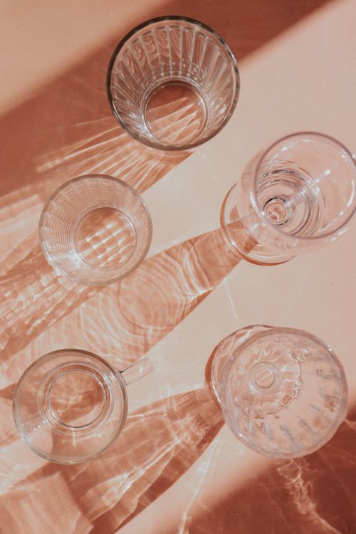 Free Top view of artistic glass cup shadows on a beige surface, creating abstract patterns. Stock Photo