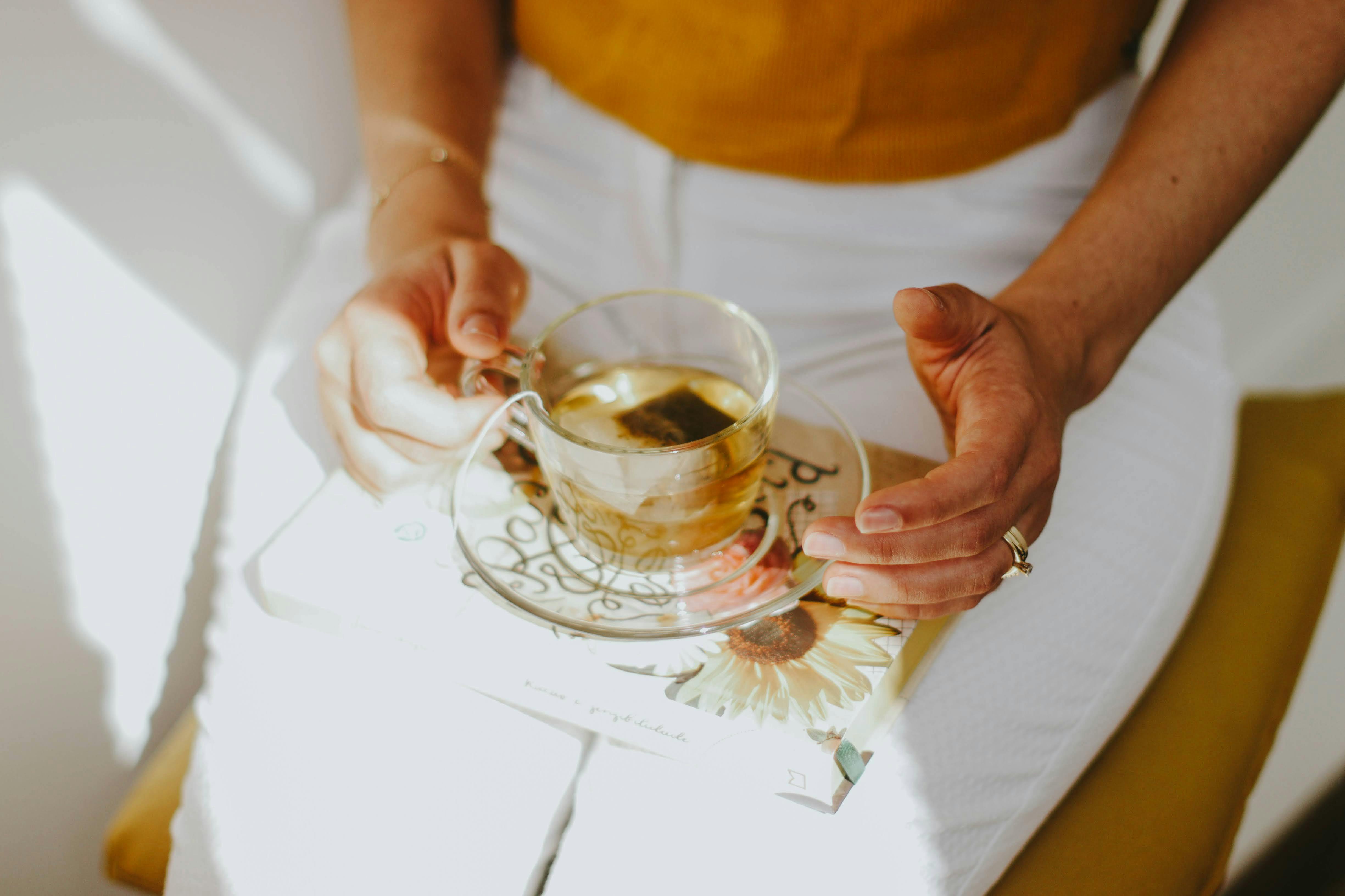 person relaxing with herbal tea and hemp - high CBD flower
