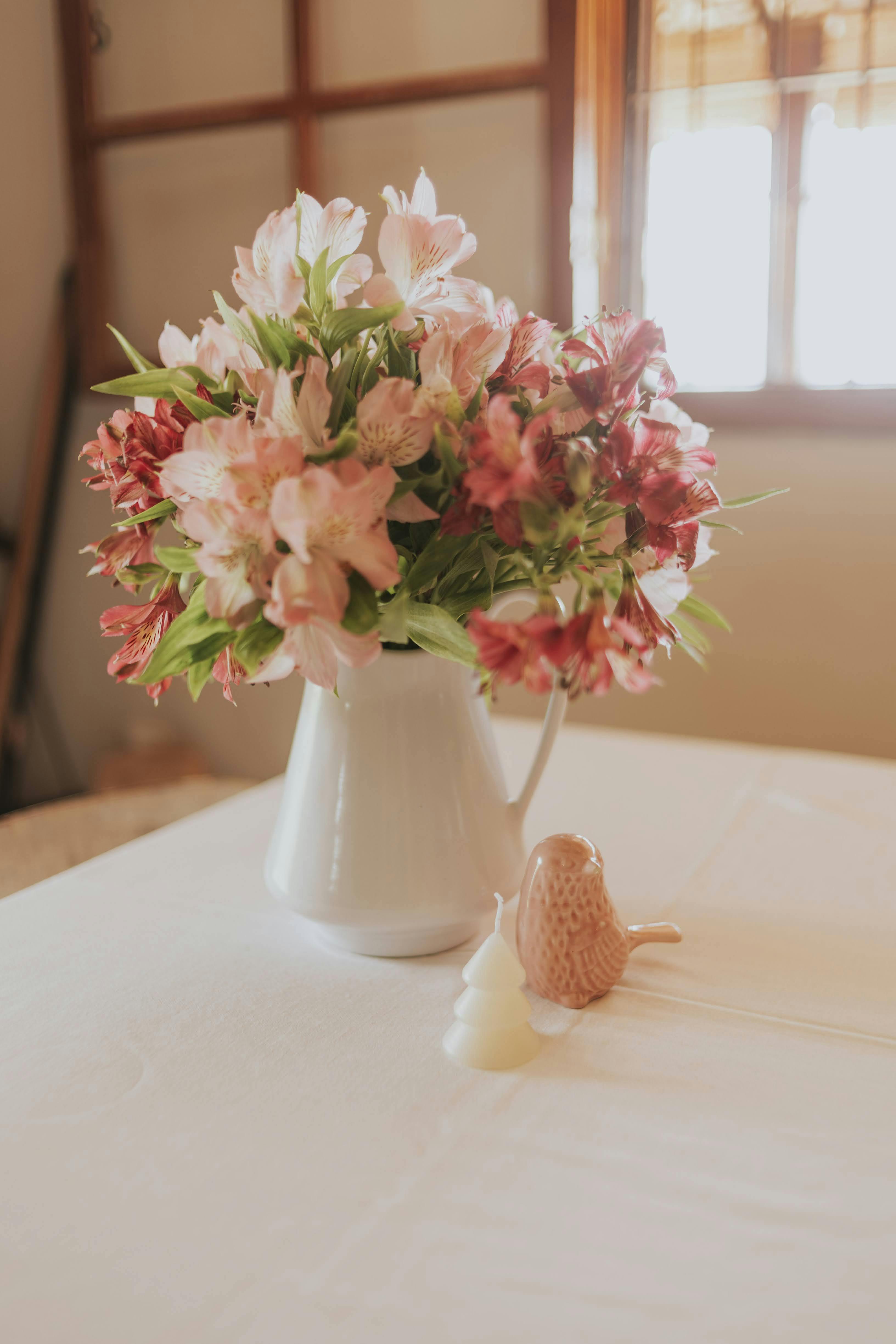 Beautiful floral bouquet in a vase on a table with ceramic decorations.