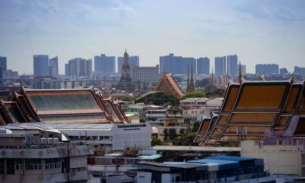 Skyline view of Bangkok highlighting traditional Thai architecture amidst modern buildings.