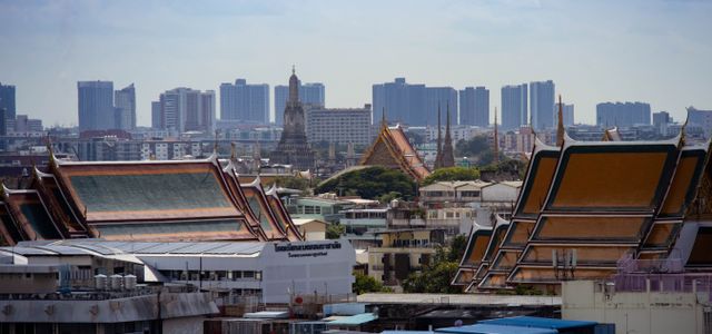 Skyline view of Bangkok highlighting traditional Thai architecture amidst modern buildings.