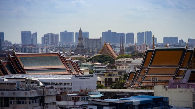 Skyline view of Bangkok highlighting traditional Thai architecture amidst modern buildings. — lounges at Bangkok Suvarnabhumi Airport