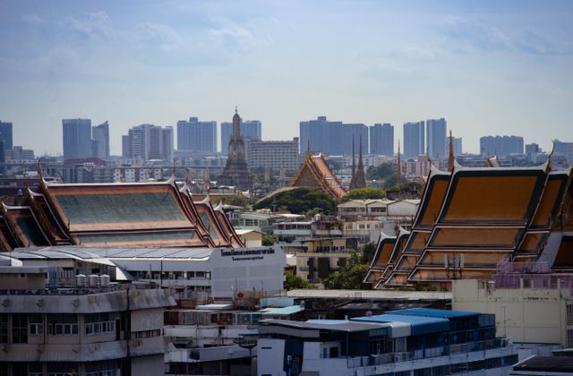 Skyline view of Bangkok highlighting traditional Thai architecture amidst modern buildings. — arriving in Bangkok