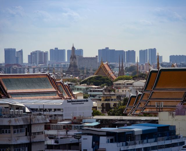 Skyline view of Bangkok highlighting traditional Thai architecture amidst modern buildings.