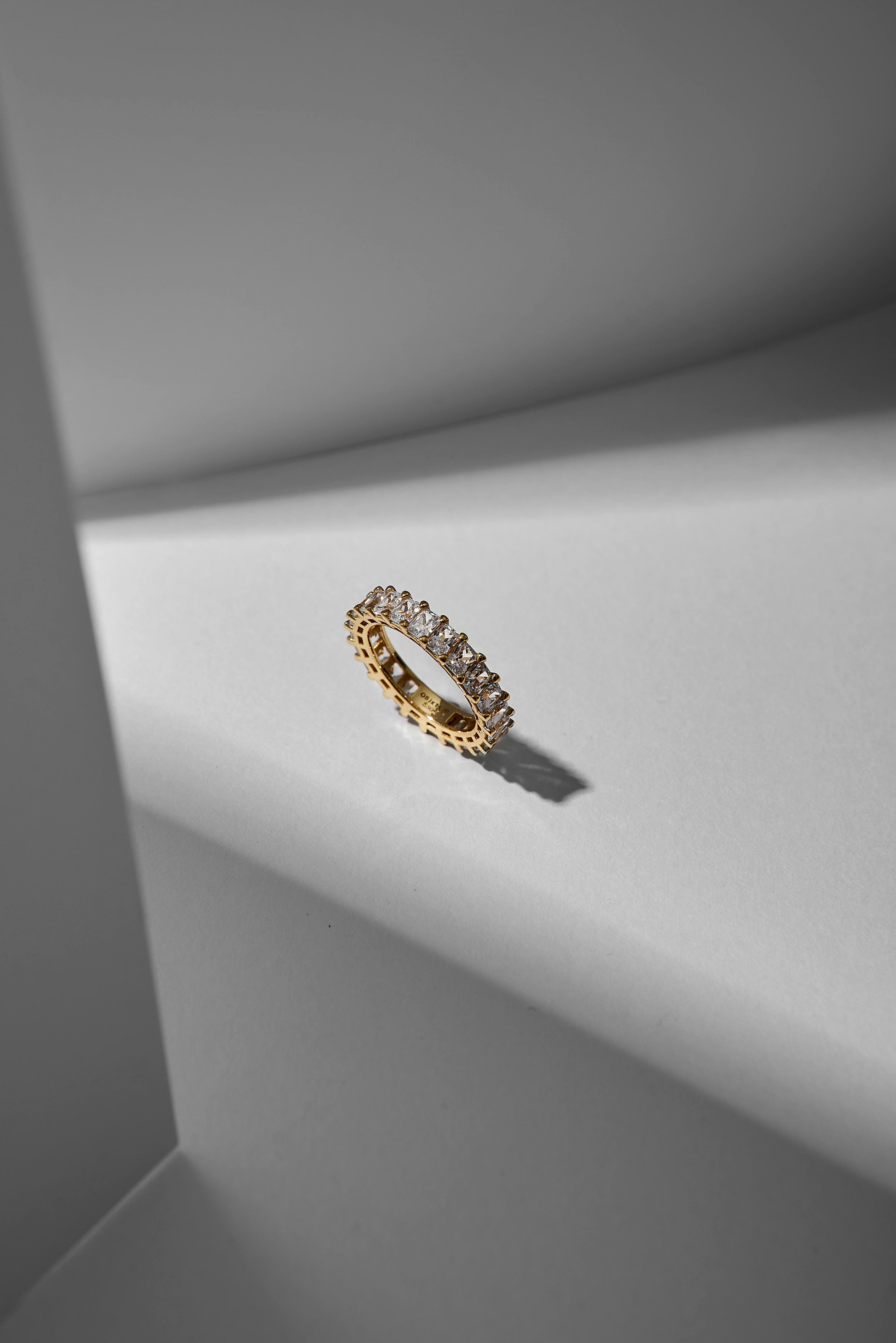 Gratis Close-up cincin berlian emas mewah dengan pencahayaan dan bayangan yang elegan. Foto Stok