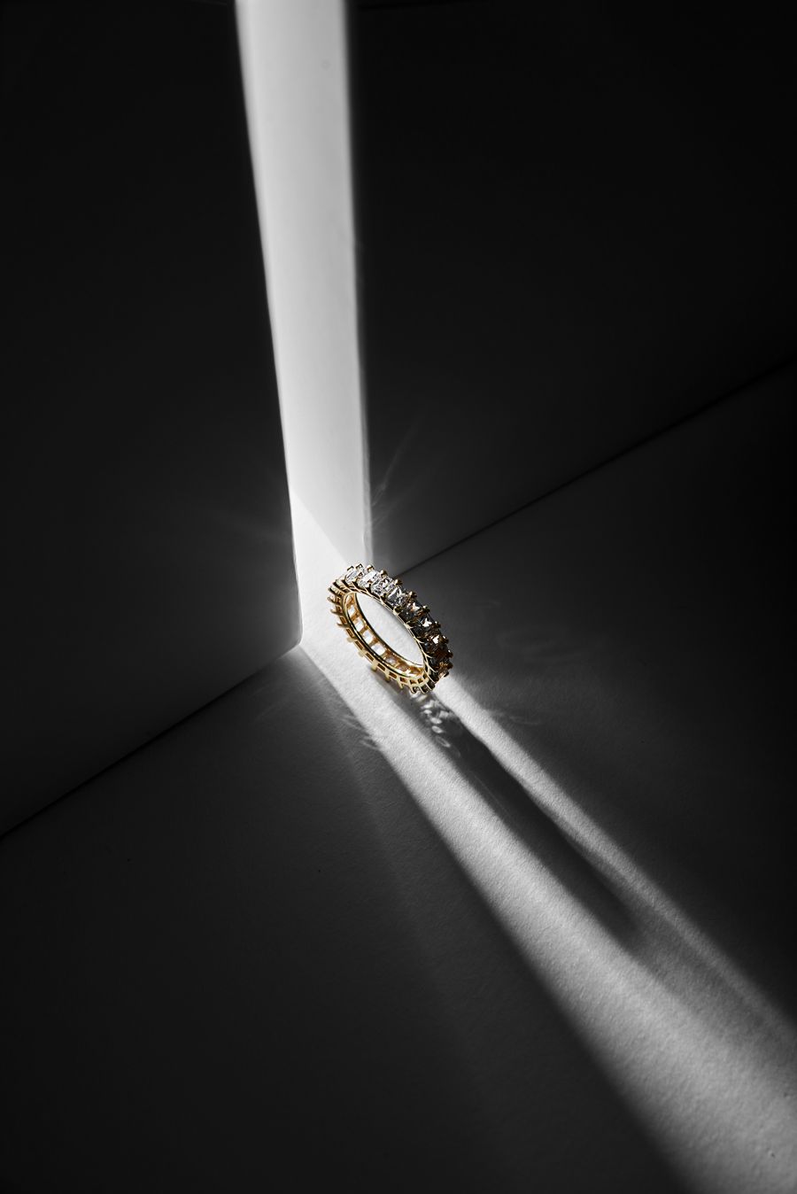Diamond and gold ring highlighted by shadows