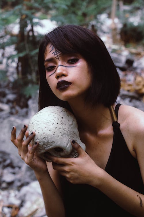Woman in Black Dress Carrrying Human Skull