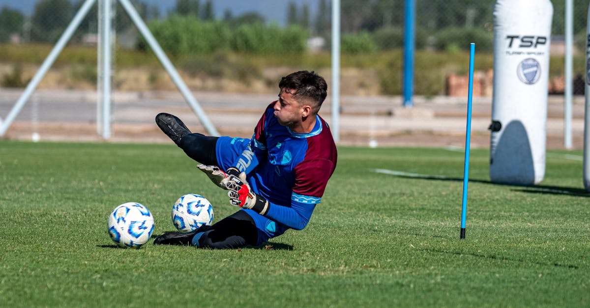 A goalkeeper in full gear practicing saves on a sunny day, showcasing dedication and skill.