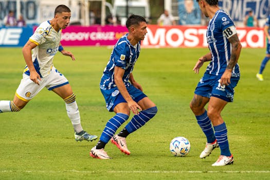 Exciting action during a soccer game with players in blue and white jerseys.
