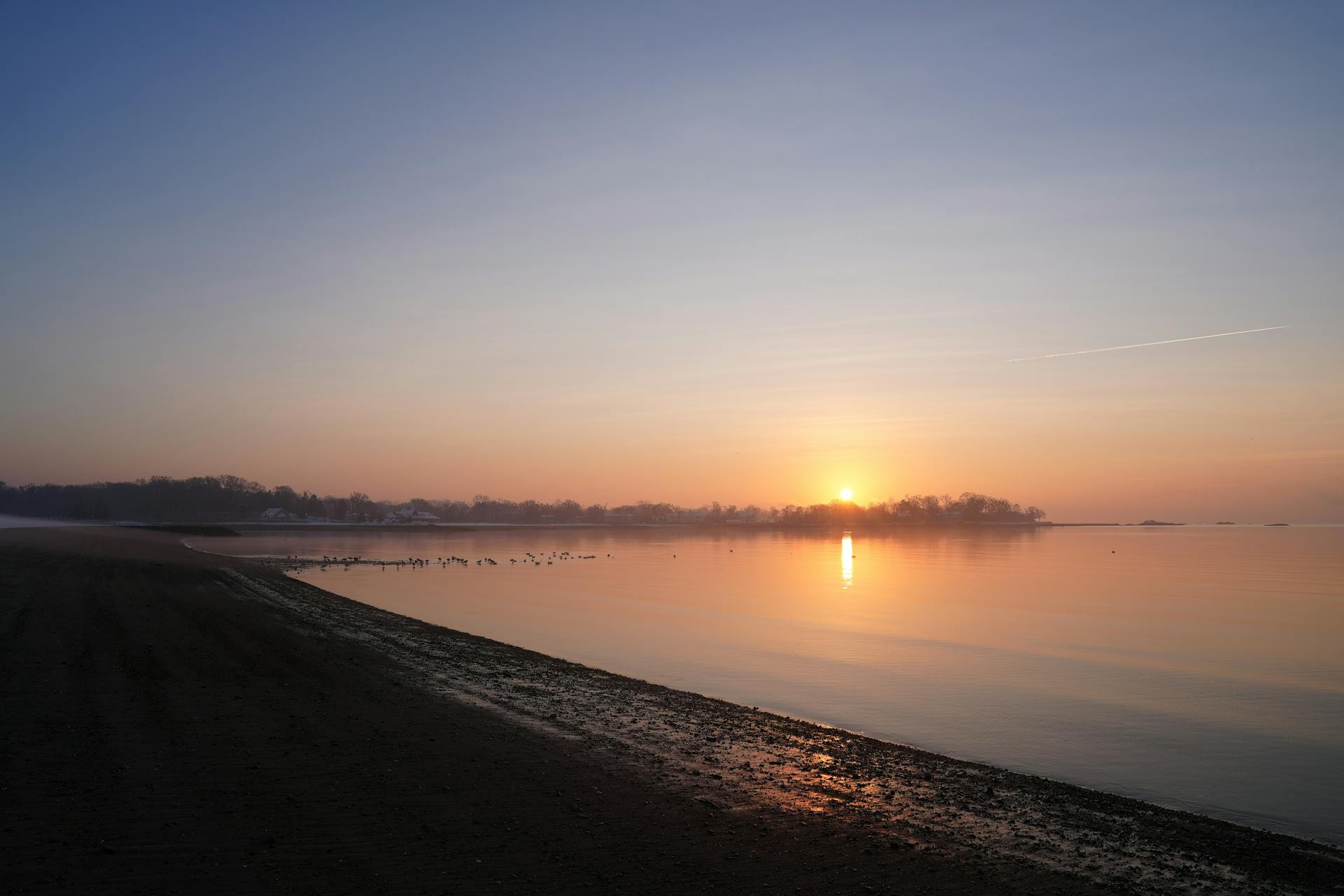 A serene winter sunrise at Stamford's Cove Island Park, Connecticut shoreline.