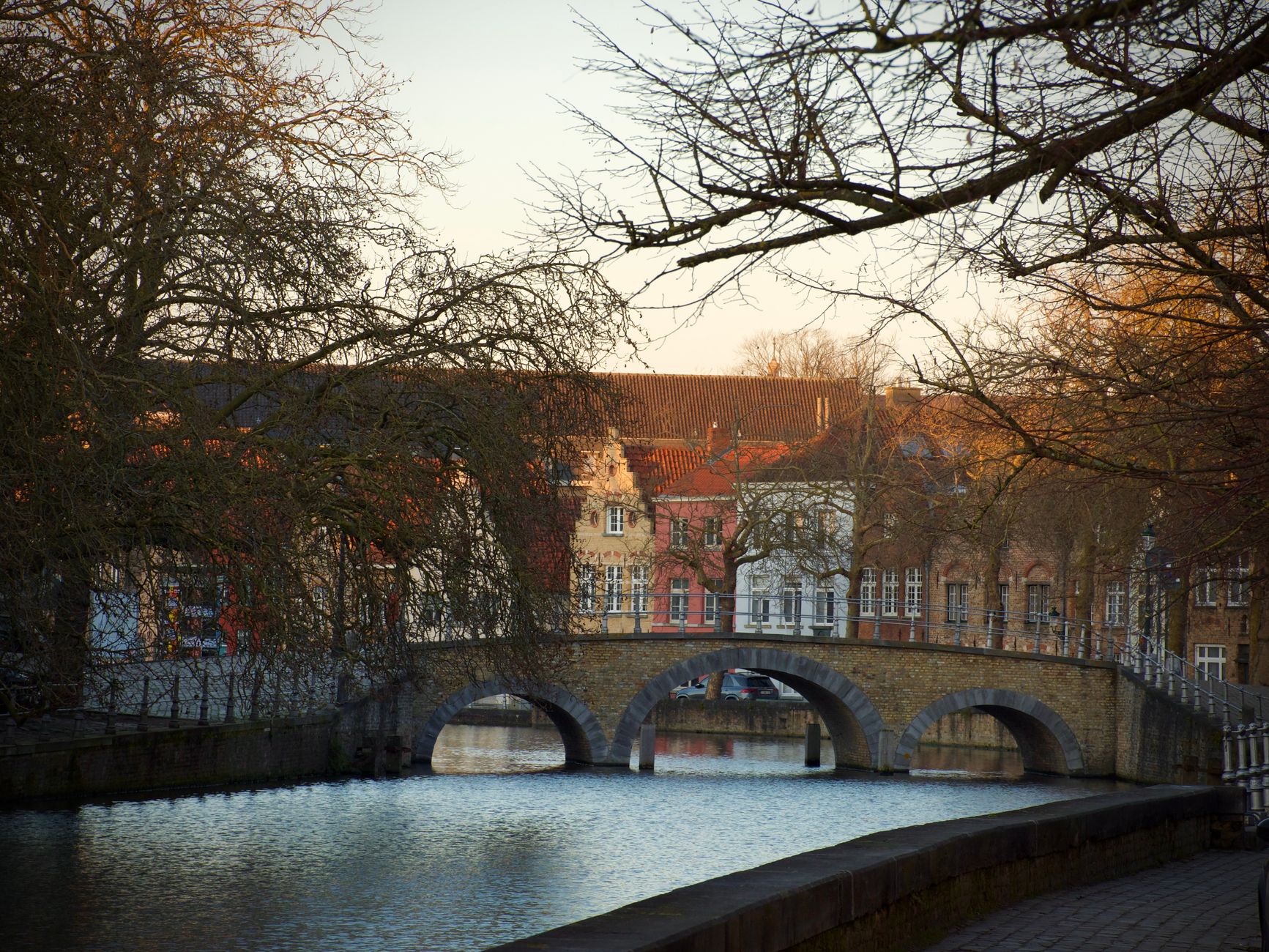 Beautiful canal view with historic bridge and colorful buildings in Bruges, Belgium.
