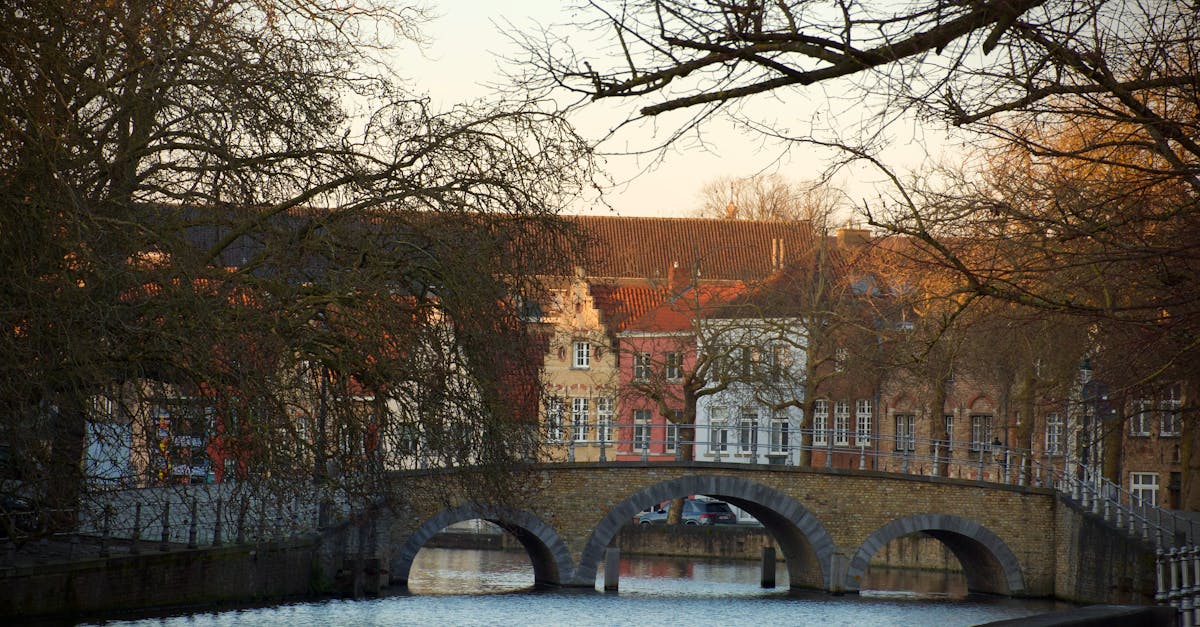 Beautiful canal view with historic bridge and colorful buildings in Bruges, Belgium.