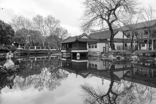 Serene view of traditional Asian architecture reflected on a calm pond.