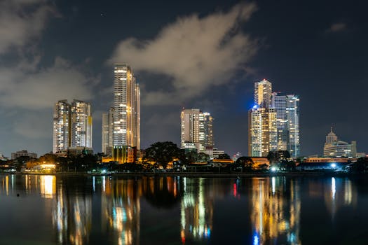 City skyline illuminated at night with stunning reflections on the waterfront.