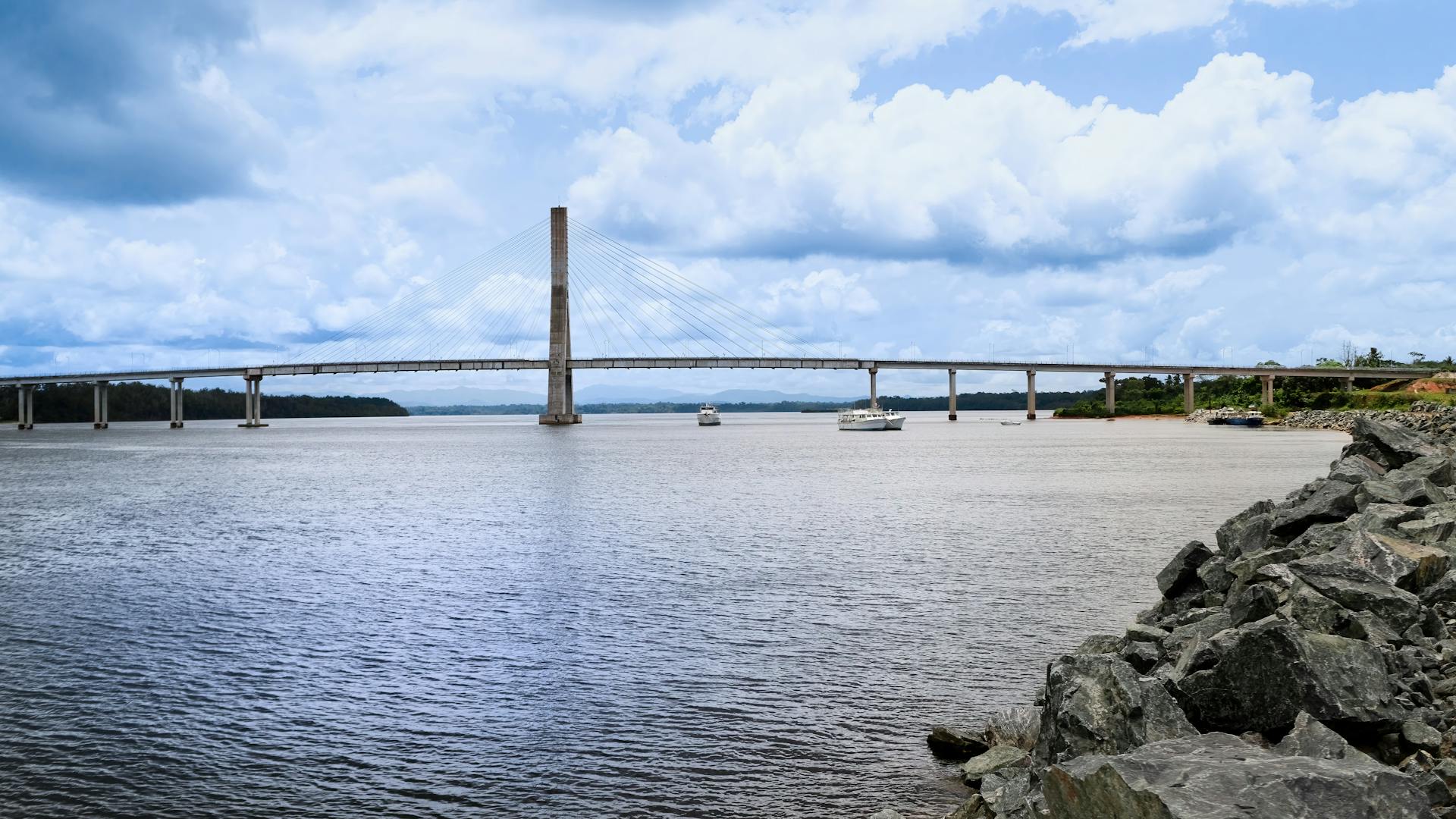 Cable-stayed bridge over river in Equatorial Guinea, showcasing modern engineering and natural beauty.