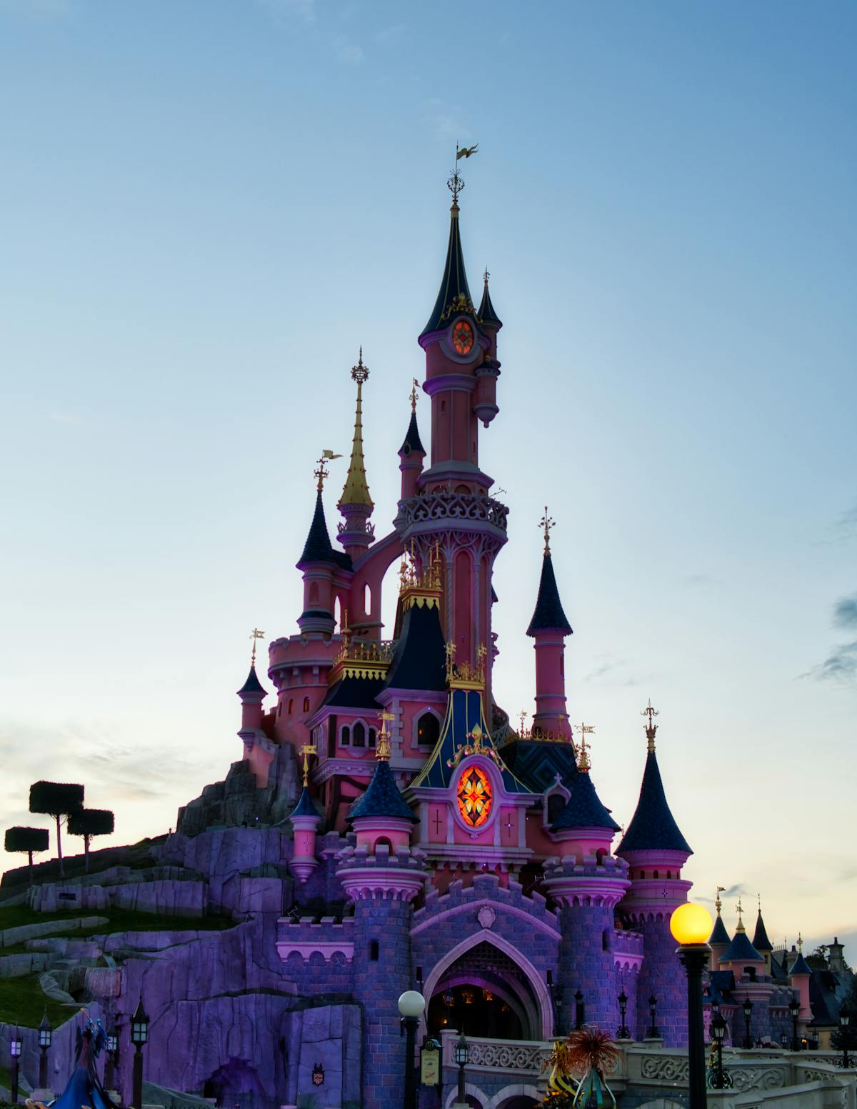 Castello di Disneyland illuminato al crepuscolo con cielo colorato sullo sfondo