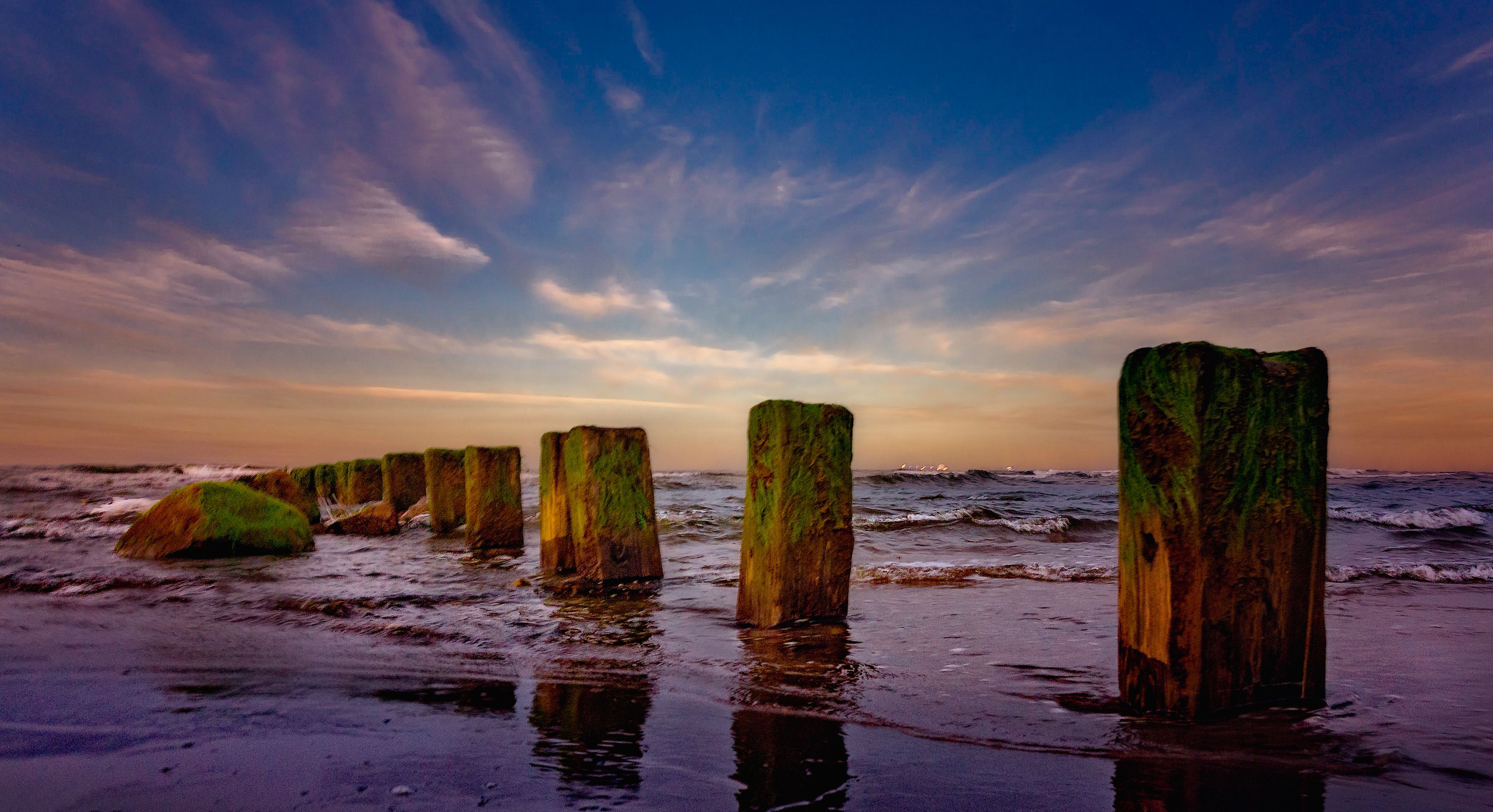 Scenic Beach with Weathered Wooden Posts and Waves · Free Stock Photo