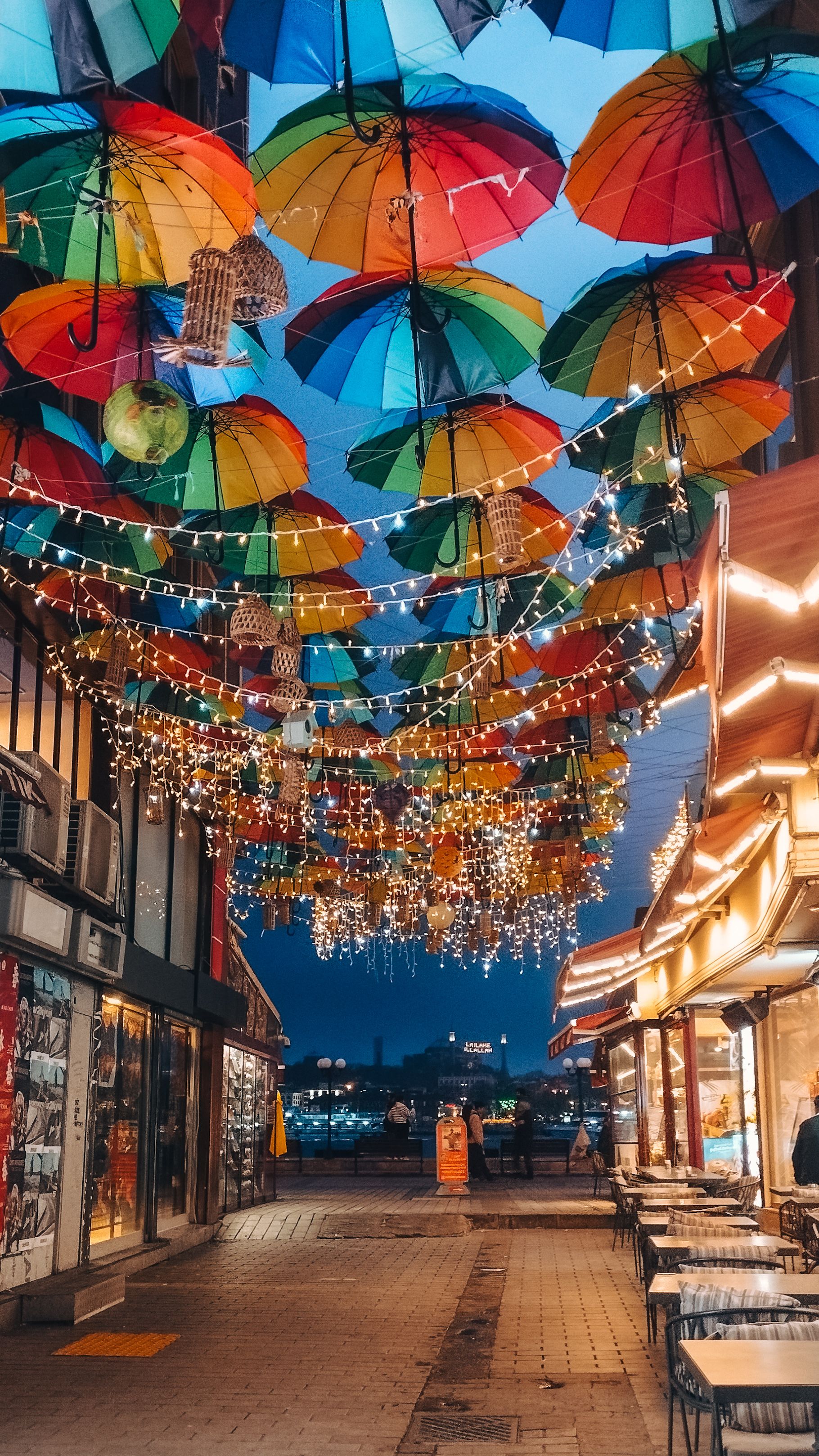 Vibrant street in Istanbul with colorful umbrellas and lights creating a festive and lively atmosphere.