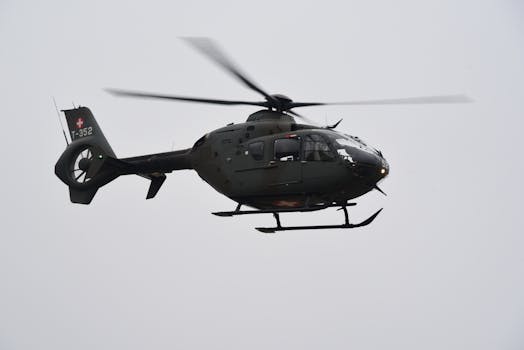 Swiss military helicopter flying under a cloudy sky in Payerne, Switzerland.
